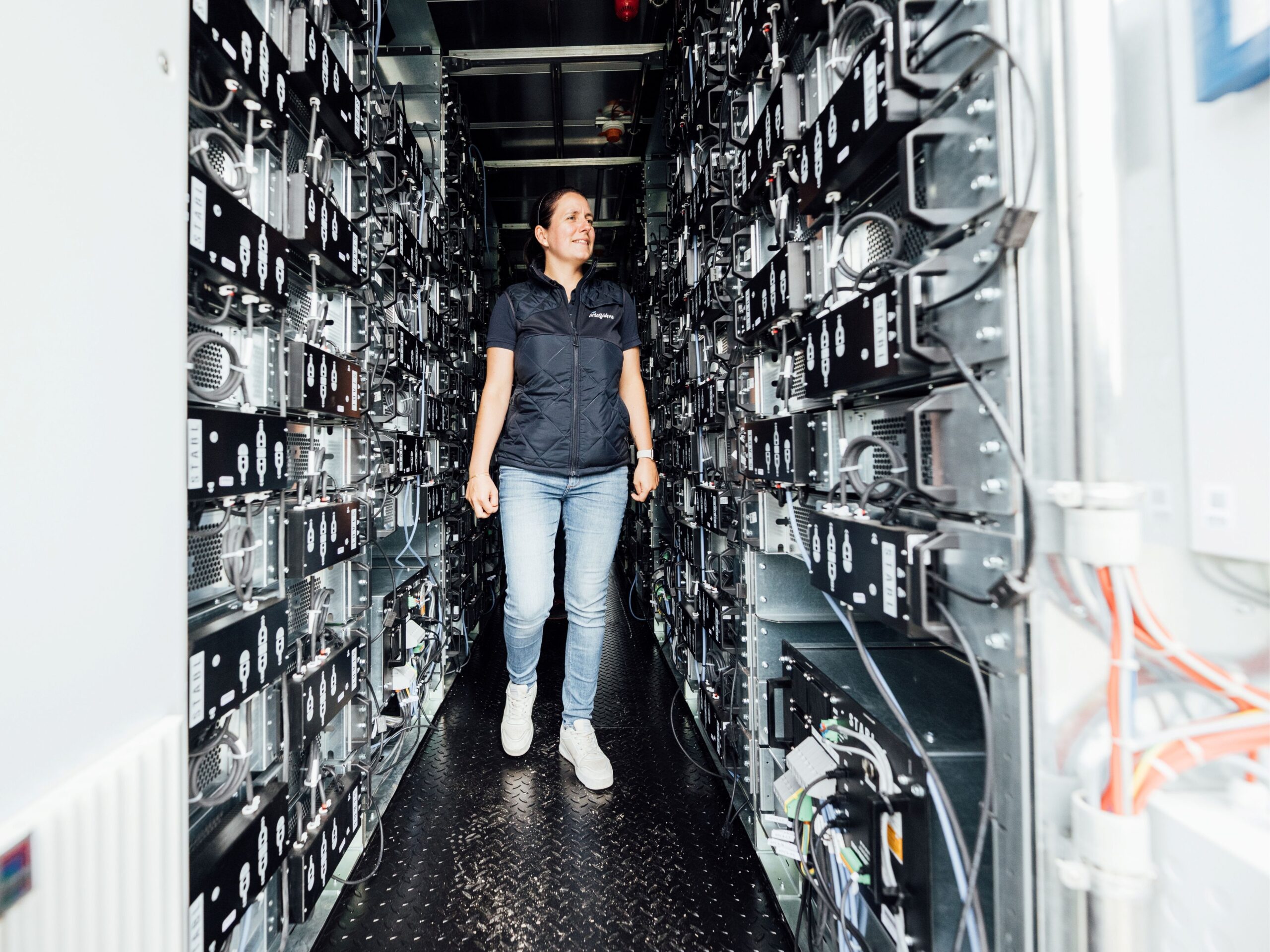 Maraike Pommer, Projektmanagerin bei der Reederei Frisia, schaut sich das Innenleben des Batterispeichers an. Quelle: STABL Energy, Janis Meyer Fotografie